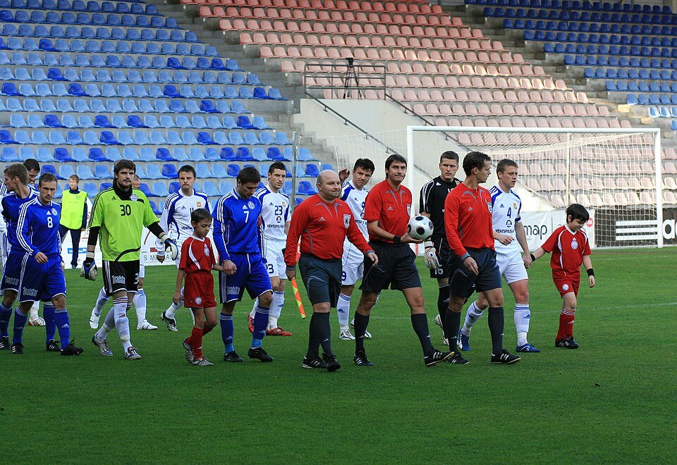 Futbola spēle uz stadiona Latvijā, skatītāji tribīnēs